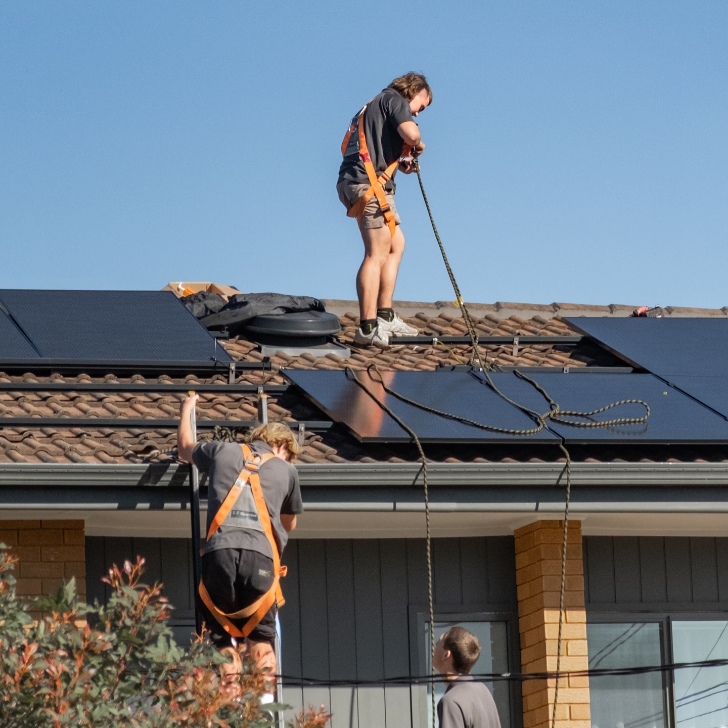 Installation crew mounting solar panels on a tile roof